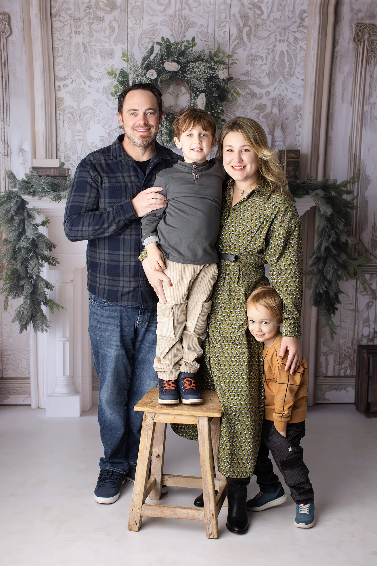 Family of four posing together indoors at Lovely Baby Photography studio in Carlsbad