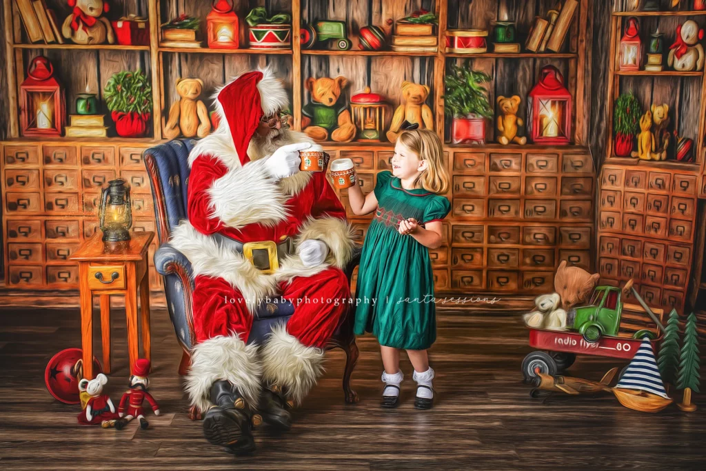 Santa Claus and a young girl clink mugs together while sitting in a cozy, toy-filled room decorated with books, teddy bears, and festive ornaments. Lovely Baby Photography, 2185 Faraday Ave suite 110, Carlsbad, CA 92008, +1 760-271-0725